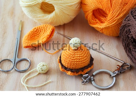 Making of handmade colorful crochet toys sweets with skein on wooden table. Selective focus