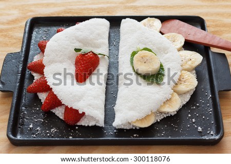 Casabe (bammy, beiju, bob, biju) - flatbread made from cassava (tapioca) with strawberry and banana on pun. Selective focus