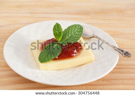 Brazilian dessert Romeo and Juliet, goiabada jam and cheese on white plate on wooden table. Selective focus