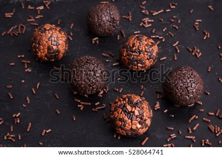 Brazilian chocolate truffle bonbon brigadeiro on black background. Selective focus