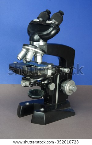 Black microscope on blue background