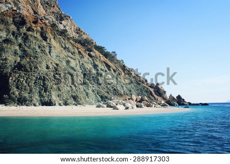 Rocky shore. Southern coast of Turkey. Calm blue sea and clear sky. Small beach on the island near Adrasan. Rocky shore. View of Mediterranean Sea. Spring sunny day in Antalya province, Turkey.