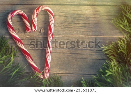 candy cane in a heart shape on a wooden surface with natural light, vintage style