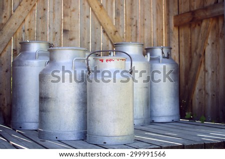 Vintage milk cans on wooden background