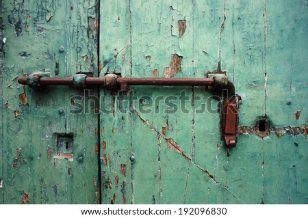 Rusted metal lock on green door