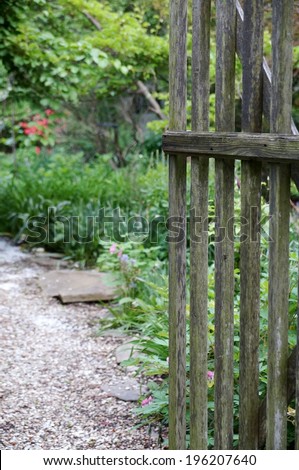 Opening the garden gate onto a gravel path and cottage garden