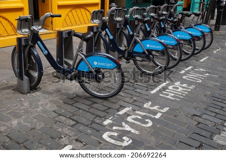 LONDON, ENGLAND - JULY 6, 2014 - Shared bikes are lined up in the streets of London. Barclays Cycle Hires, launched in July 2010, has over 720 stations and 10,000 bikes throughout London.
