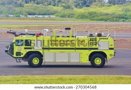 KAHULUI, HI -28 MARCH 2015- Editorial: Yellow fire trucks ride to meet an airplane at Kahului Airport (OGG) on the island of Maui in Hawaii near the Haleakala volcano.