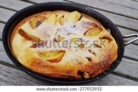 Peach Dutch pancake in a pan with powdered sugar