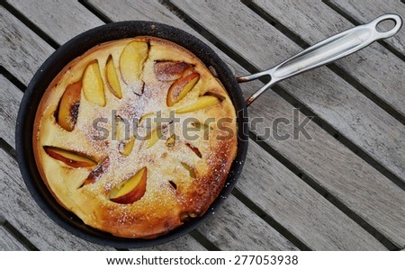 Peach Dutch pancake in a pan with powdered sugar