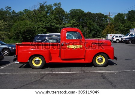PRINCETON, NJ -7 JULY 2015- A vintage retro flaming red Ford pickup truck serving as an advertisement for the hardware chain stores Ace Hardware.