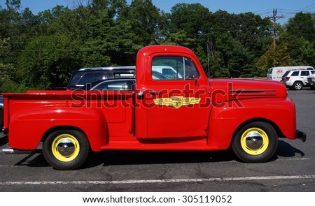 PRINCETON, NJ -7 JULY 2015- A vintage retro flaming red Ford pickup truck serving as an advertisement for the hardware chain stores Ace Hardware.