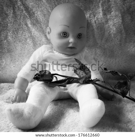 Baby doll sitting with dry rose,concept of love