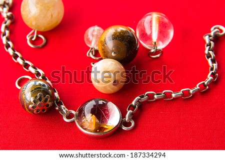 Silver bracelet ,Glass with  stones and glass beads in  on a red background