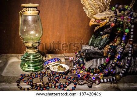 Still life with art jewelry vintage,oil lamp, necklace and eagle
