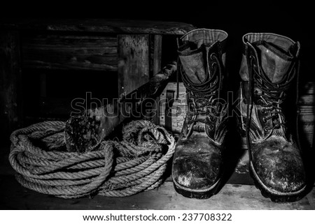 Still life art photography old boots on wooden table over grunge,Black and white tone