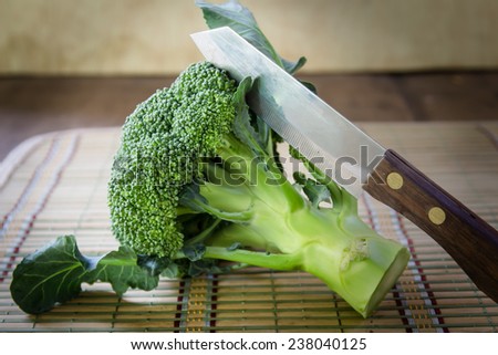 Fresh raw broccoli with knife on table ,organic vegetable