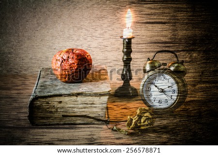 Double exposure of still life art photography,apple on book with clock and candle