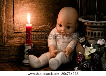 Still life art photography  with doll and candlelight on table,sad concept
