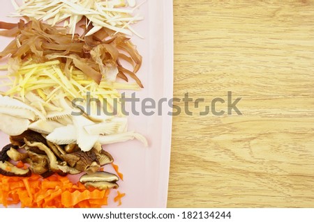 Carrot, lentinula, oyster mushroom, ginger, auricularia slice put on pink tray with wood background.
