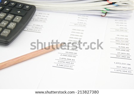 Stack of account with calculator and pencil place on balance sheet.