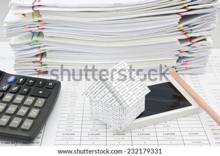 House on smartphone with pencil and calculator place on finance account with pile of paperwork as background.