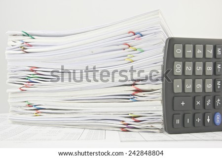 Stack paperwork of sales and receipt with calculator place on finance account.