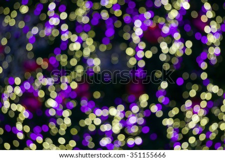 Defocused of glitter or yellow and purple bokeh circle at night as background.