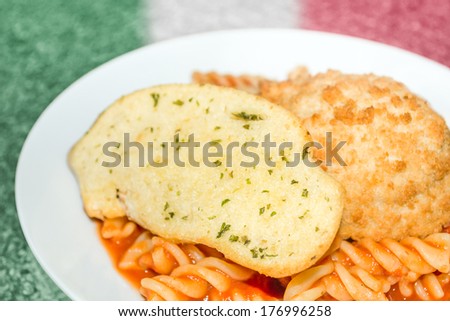 Fusilli (spiral) pasta with a tomato and basil sauce. Topped with garlic bread and breaded garlic chicken.
