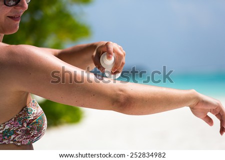 Woman protects her skin on the Beach and applies lotions