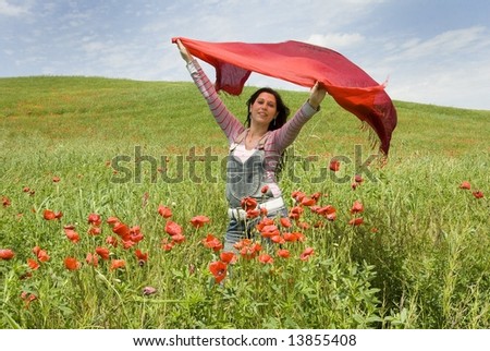 Red explosion, cute girl with red scarf stands among red poppies