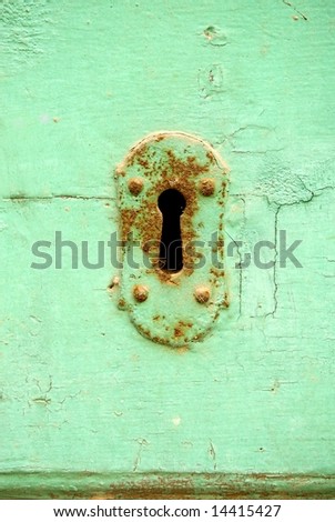 Rusty key slot on turquoise antique door