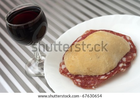 Sandwich with ham and a cup of red wine