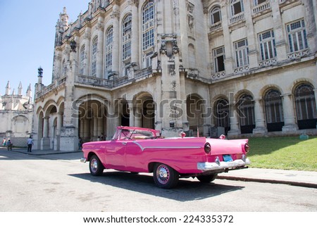 HAVANA - CIRCA MARCH 2008 - Bright pink convertible in front of ornate government building in Old Havana