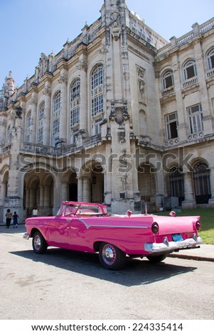 HAVANA - CIRCA MARCH 2008 - Bright pink convertible in front of old colonial era building in Old Havana