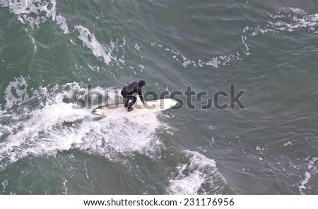 SAN FRANCISCO, CA, USA - APRIL 2010: Aerial View of surfer in wet suit riding a wave. San Francisco Bay, California, USA