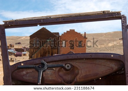 Unique vantage point looking out to ghost town of Bodie, California from inside of abandoned jalopie