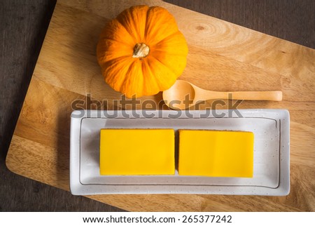 pumpkin cake and twin doll on wooden table