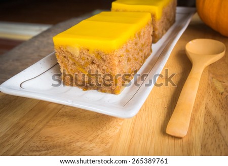 pumpkin cake and twin doll on wooden table