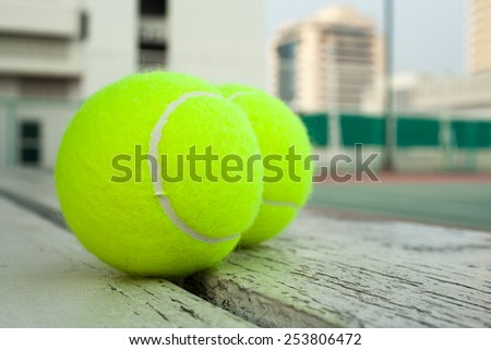tennis balls and a hard court on a roof of high building