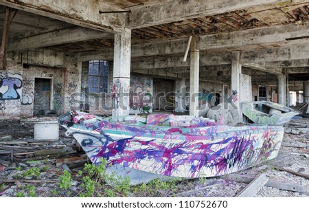 Abandoned factory with a boat being used as a piece of art. Multiple area\'s painted with graffiti.