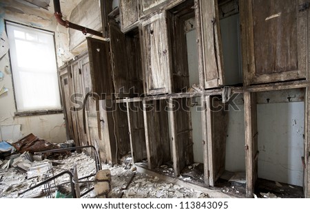 Abandoned school in Detroit Michigan. The cabinets are falling apart and papers are scattered on the floor.