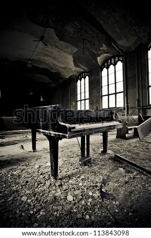 Interior of an abandoned school there is a grand piano that has been left to the ravages of time in Detroit Michigan .