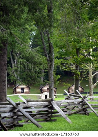 Log cabins behind an old fashioned split rail fence. Continental army soldiers stayed here at Valley Forge winter 1777-1778