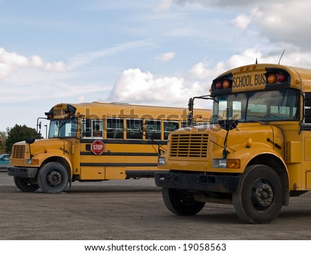 Two school bus\'s parked and awaiting their students