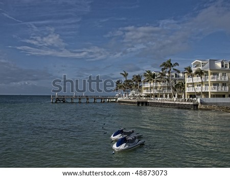 New apartment buildings condominiums on the beach in Key West. There is a pair of water craft waiting for passengers.