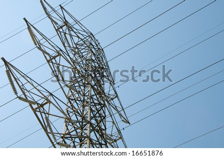 Tall electrical distribution tower against blue sky