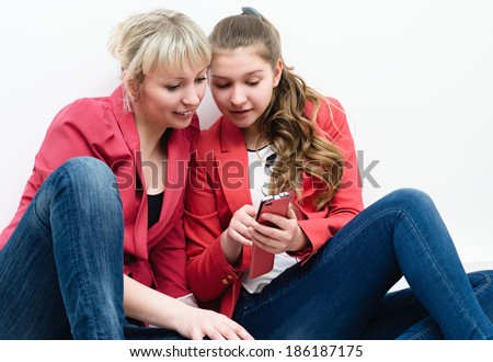 two young attractive young women with interest studying phone