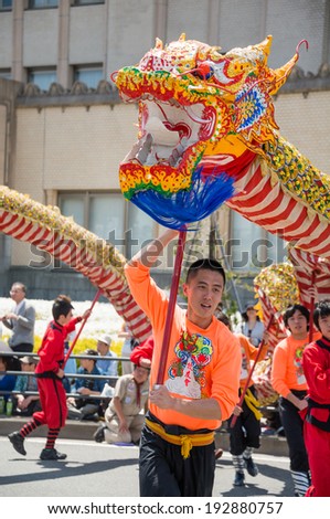 YOKOHAMA, JAPAN - MAY 3, 2014: Chinese students are performing a dragon dance on the street in \
