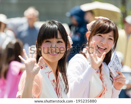 YOKOHAMA, JAPAN - MAY 3, 2014: Young women in costume are waving to spectators in \